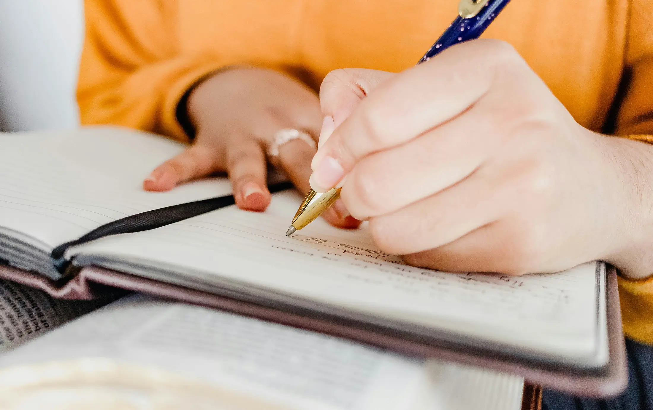 close up of someone writing into a journal
