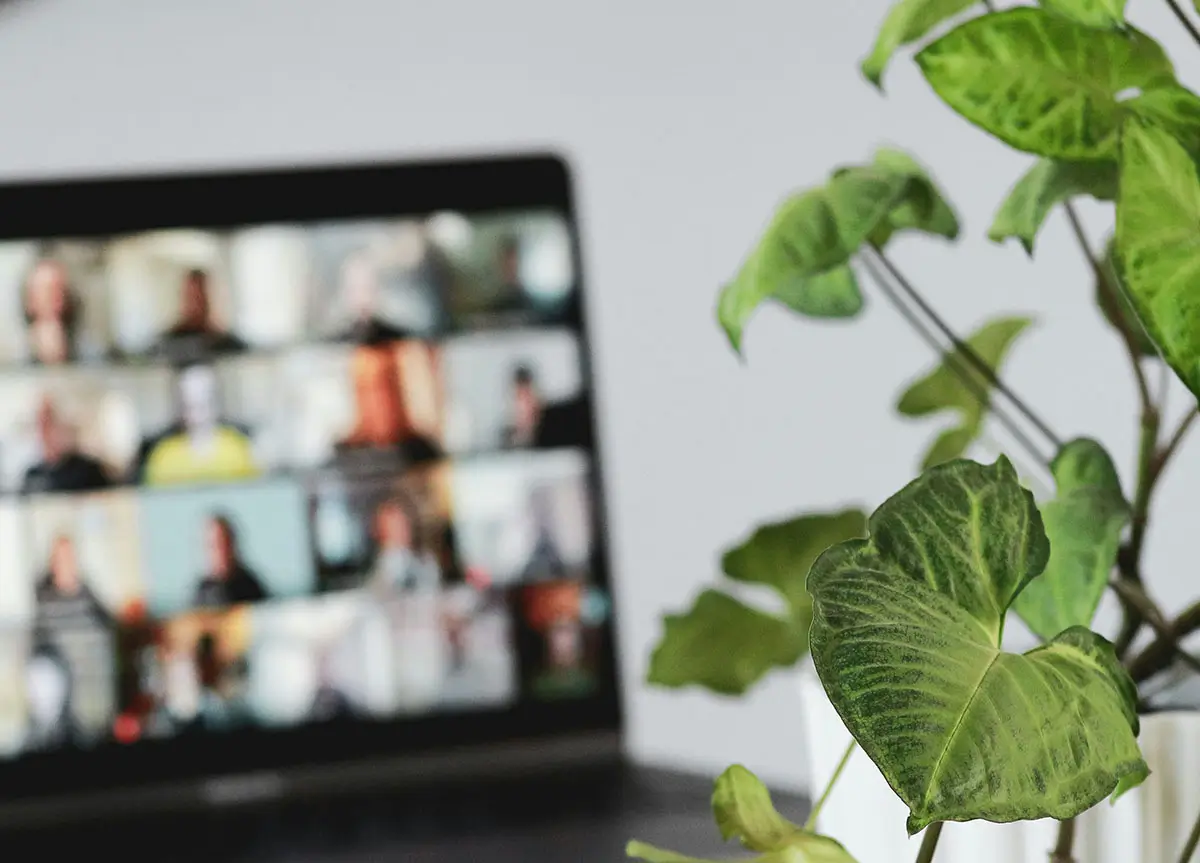 A laptop screen showing a group of people in an online meeting